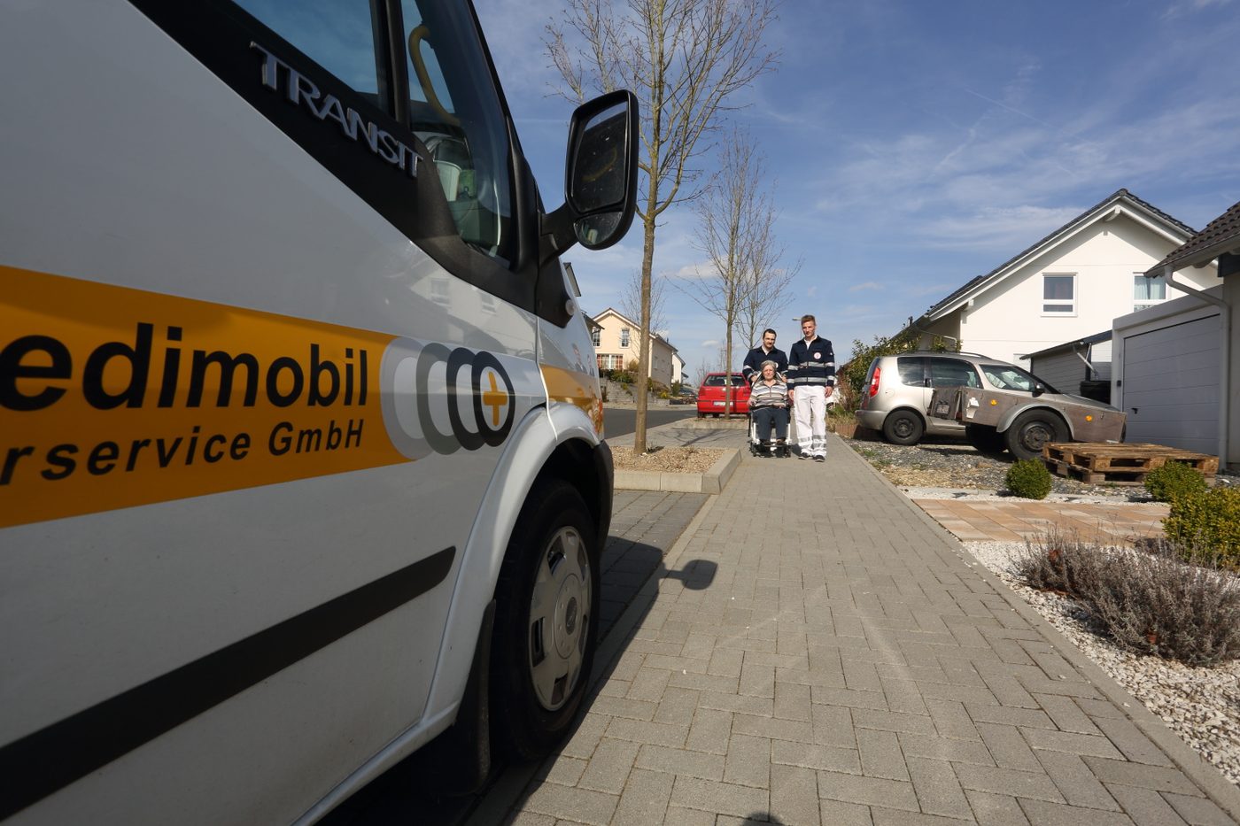 Krankenfahrzeug der Medimobil Fahrservice GmbH von der Seite mit Firmenbeschriftung